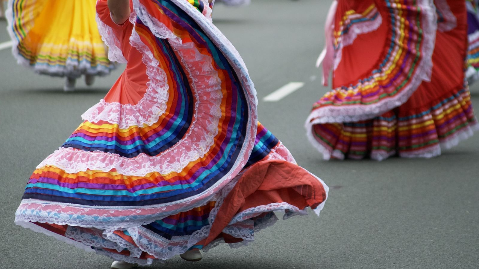A close up shot of a few street performers dancing in elaborate dresses.