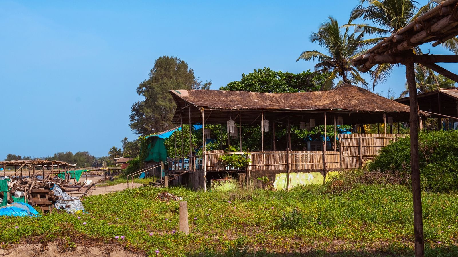 A hut constructed next to the beach with greenery around it