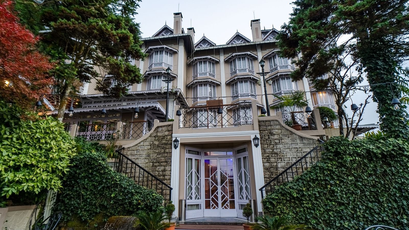 Front entrance to Cedar Inn with stairs and lush greenery