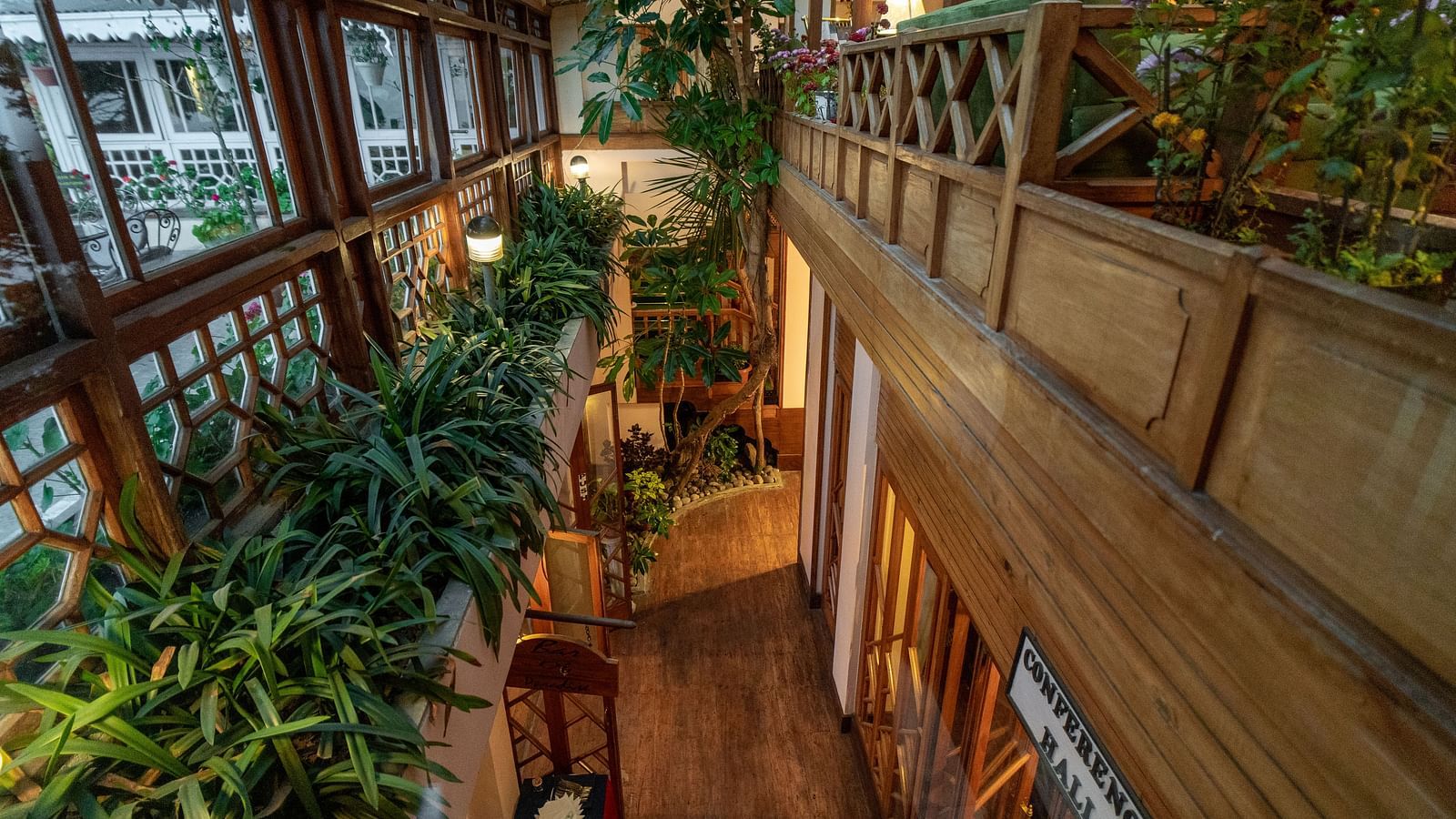 Wooden corridor with plants and large windows at Cedar Inn