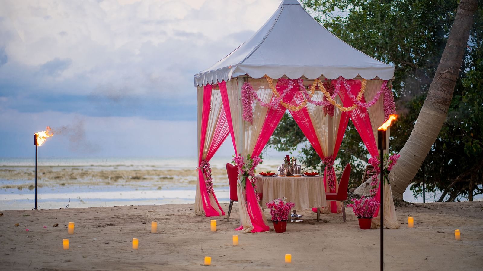 View of romantic dinner setup by the beach  at Coral Reef Hotel & Resort