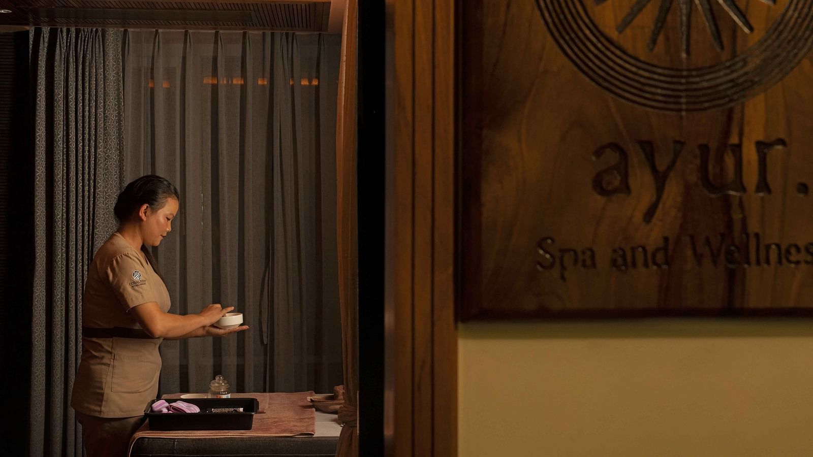 A masseur making the preparations for a spa session.