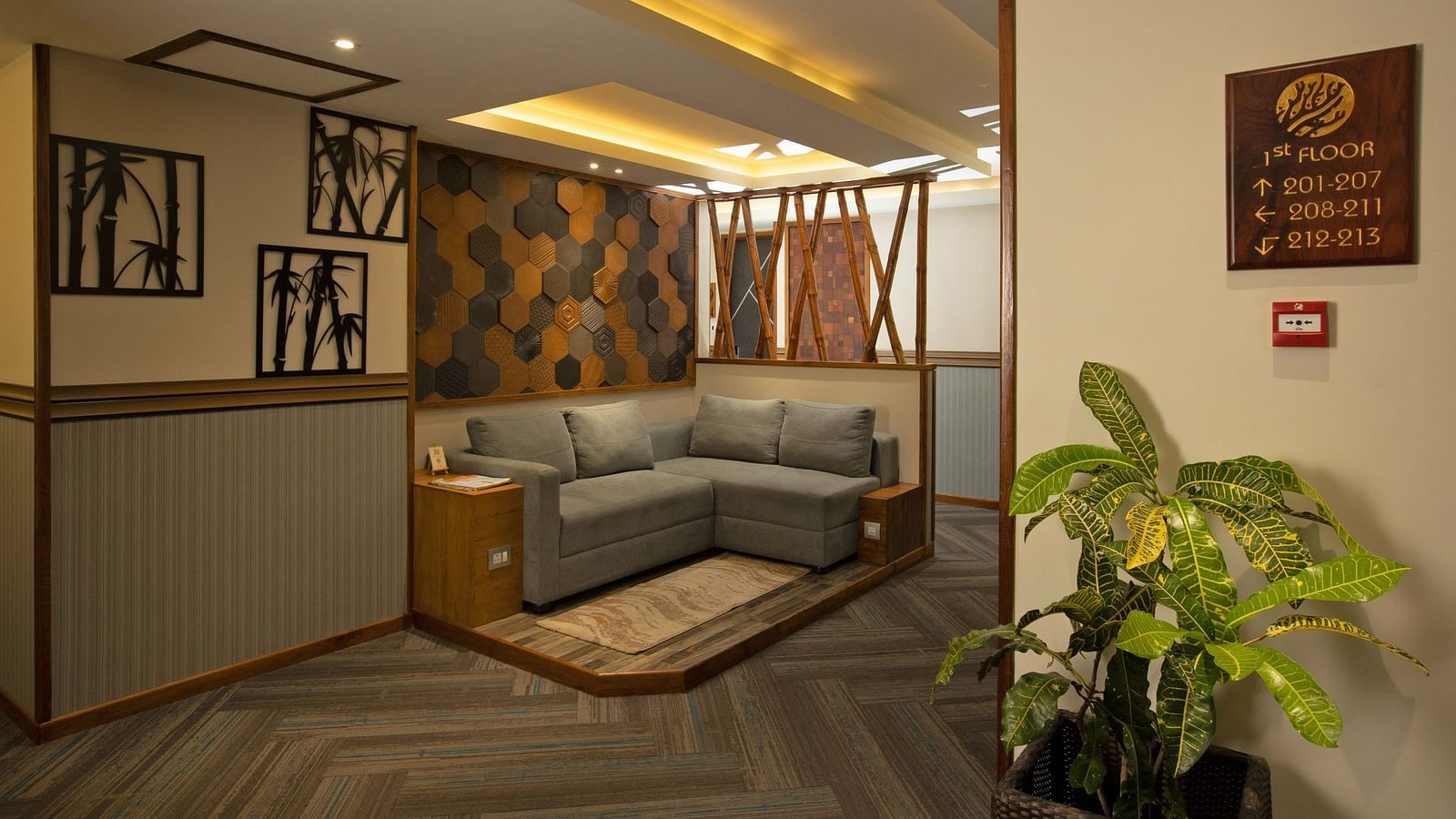 Image of the lobby area at Coral Reef Hotel and Spa in Port Blair featuring a seating space with L shape sofa and wall hangings and plant 