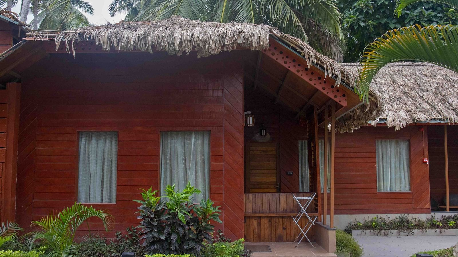 Image of the facade of Coral Azure at Coral Reef Resort and Spa in Havelock featuring the huts and tiny shrubs around the premises on a cloudy day
