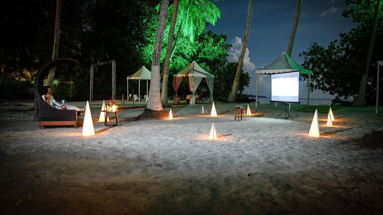 Couple watching a movie on the White screen with a movie showing on the beach - Coral Reef Resort & Spa, Havelock