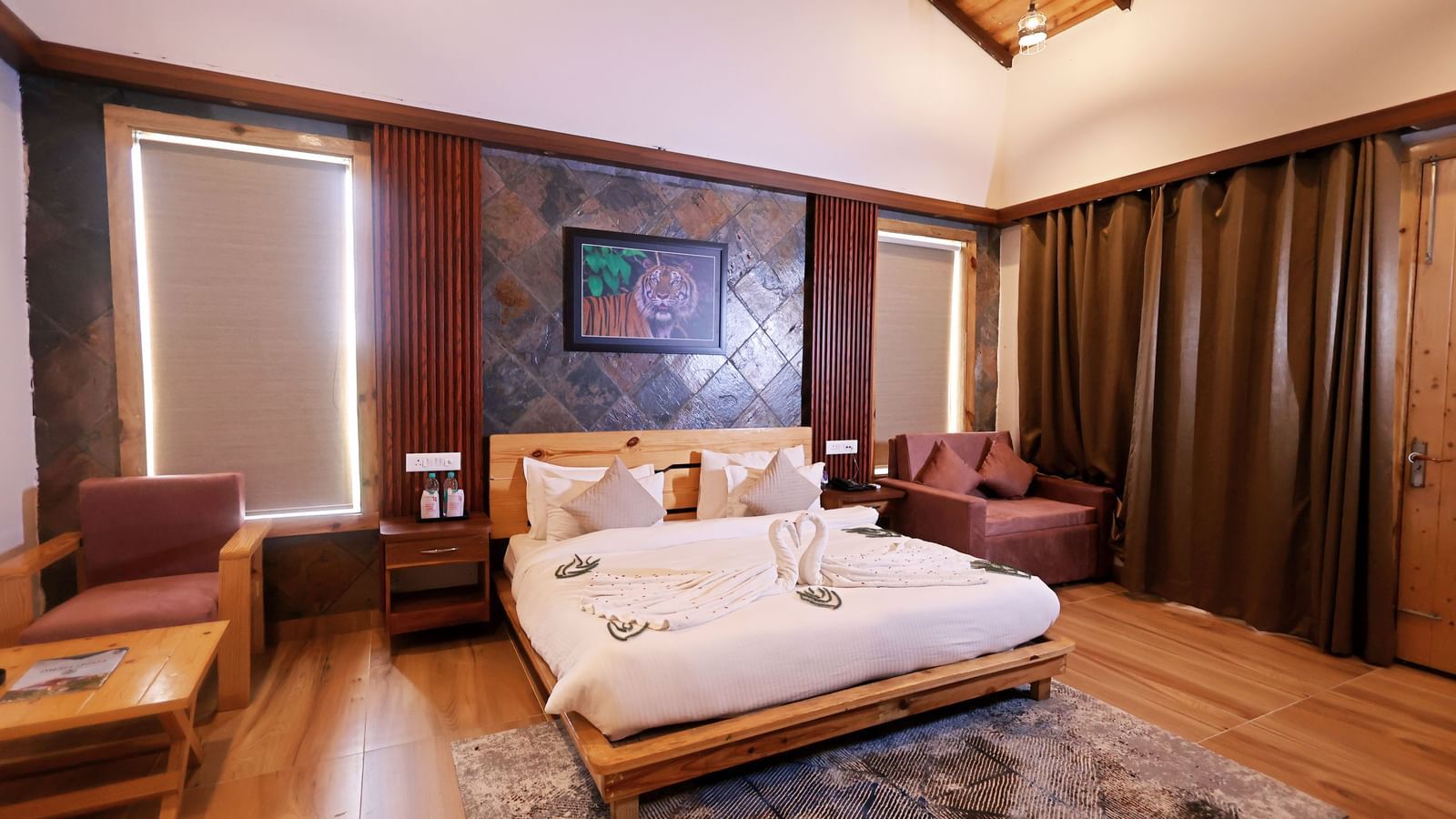 Elegant bedroom with plush bedding, warm tones, and chic decor at Corbett Nirvana Resort.