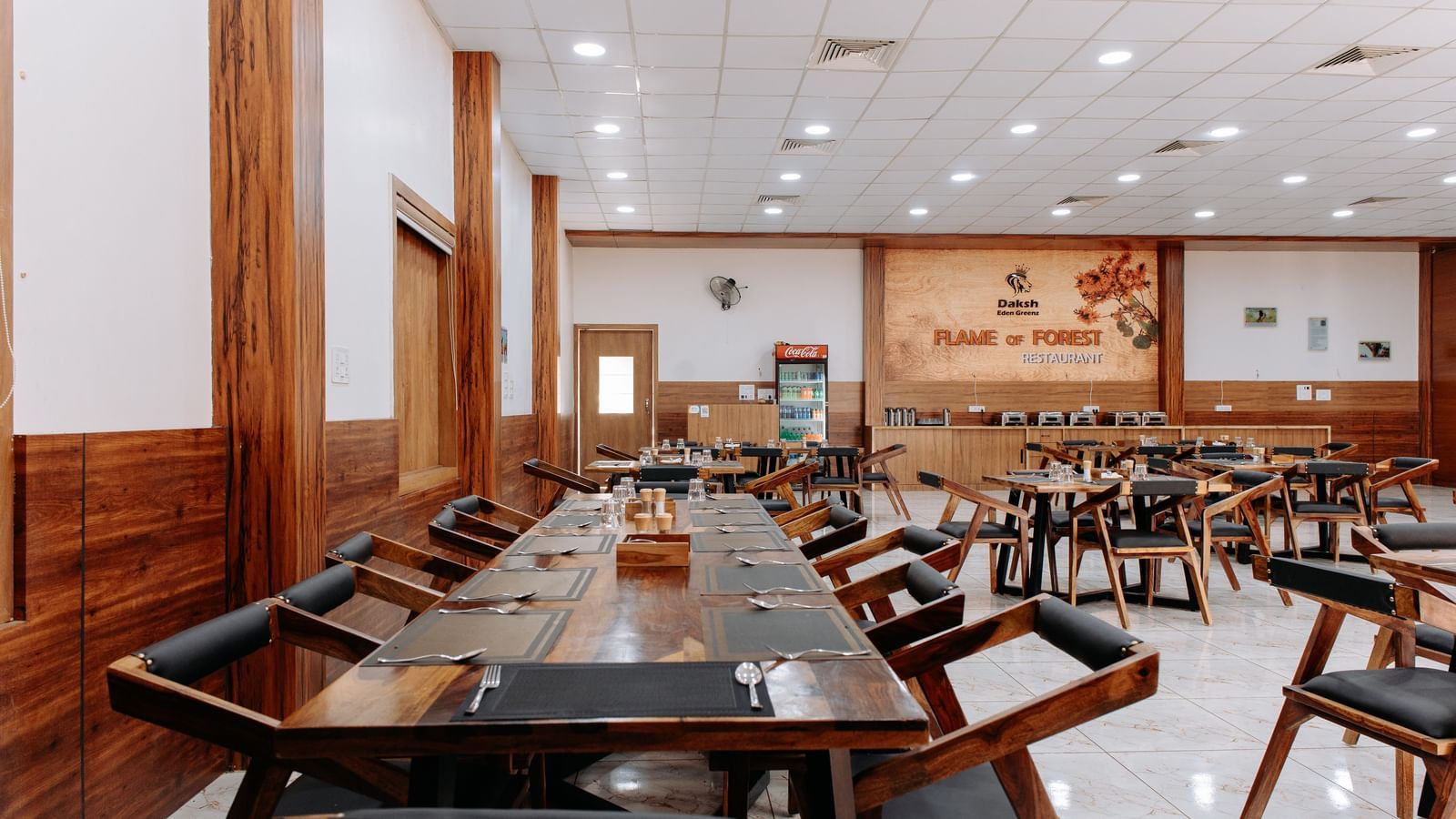 Close up view of dining tables placed spaciously at the restaurant in Daksh Eden Greenz, Sasan Gir.