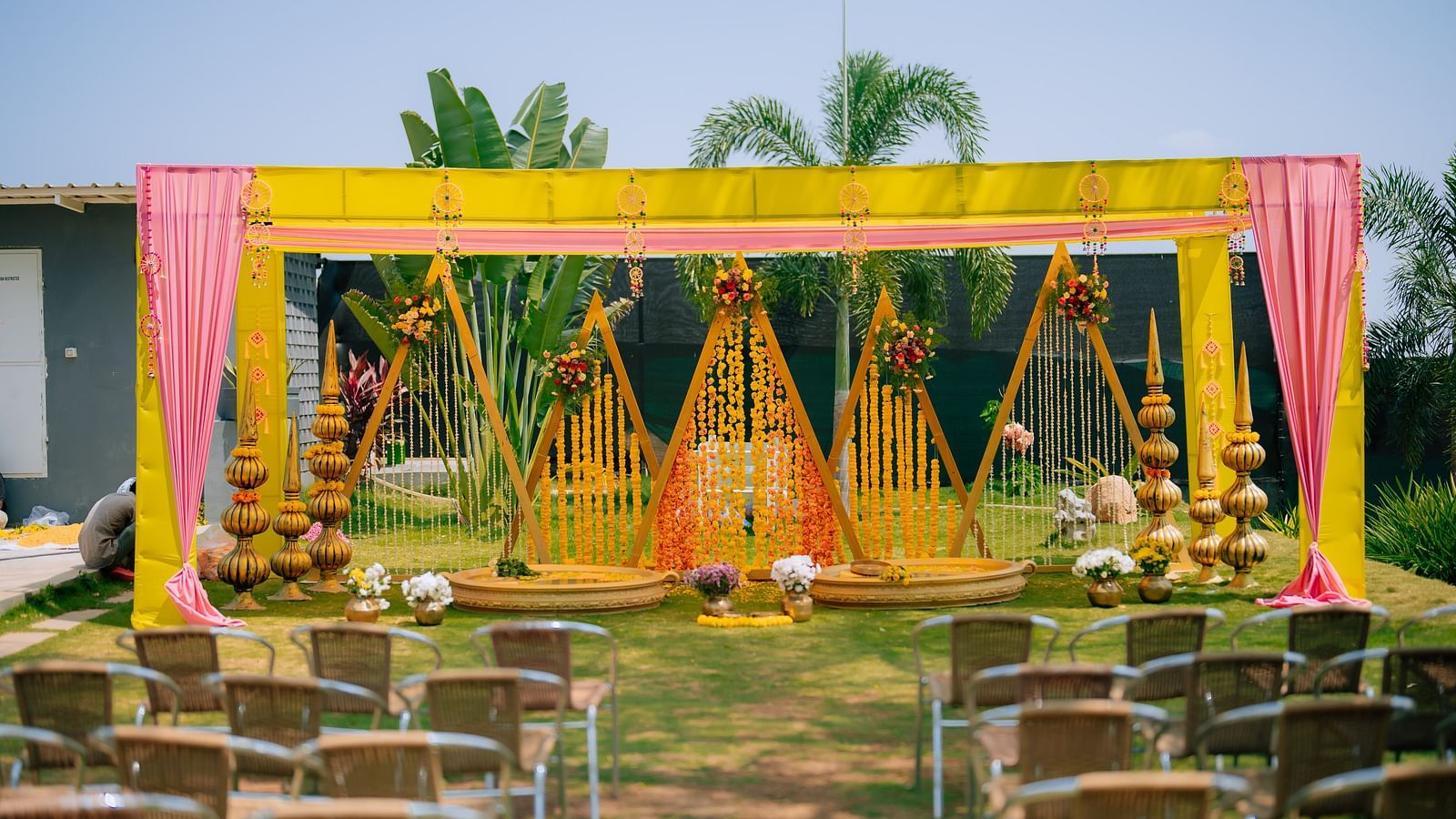 image of the decoration of haldi ceremony with several chairs placed facing towards the stage