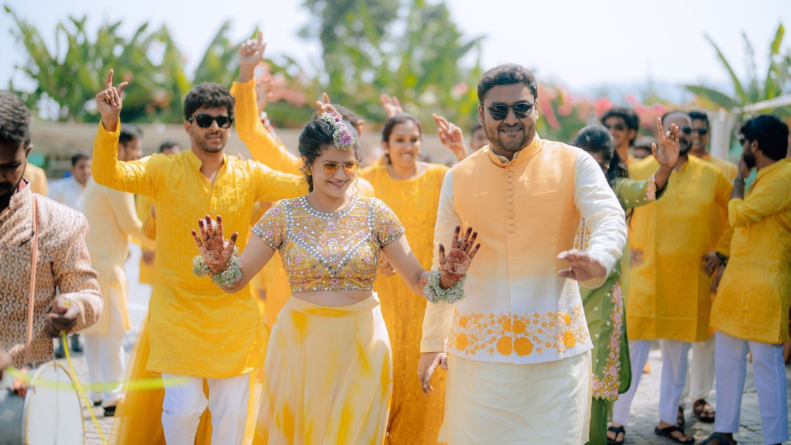 image featuring the couple with their freinds and family dancing in the background with yellow colour as the dress code at darza resorts
