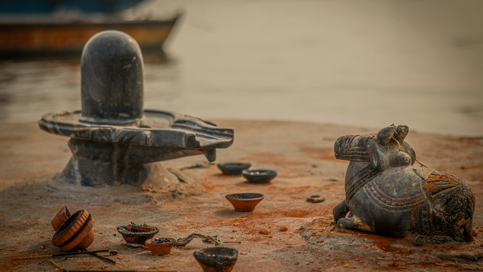 diyas around idols of a cow in front of a lingam