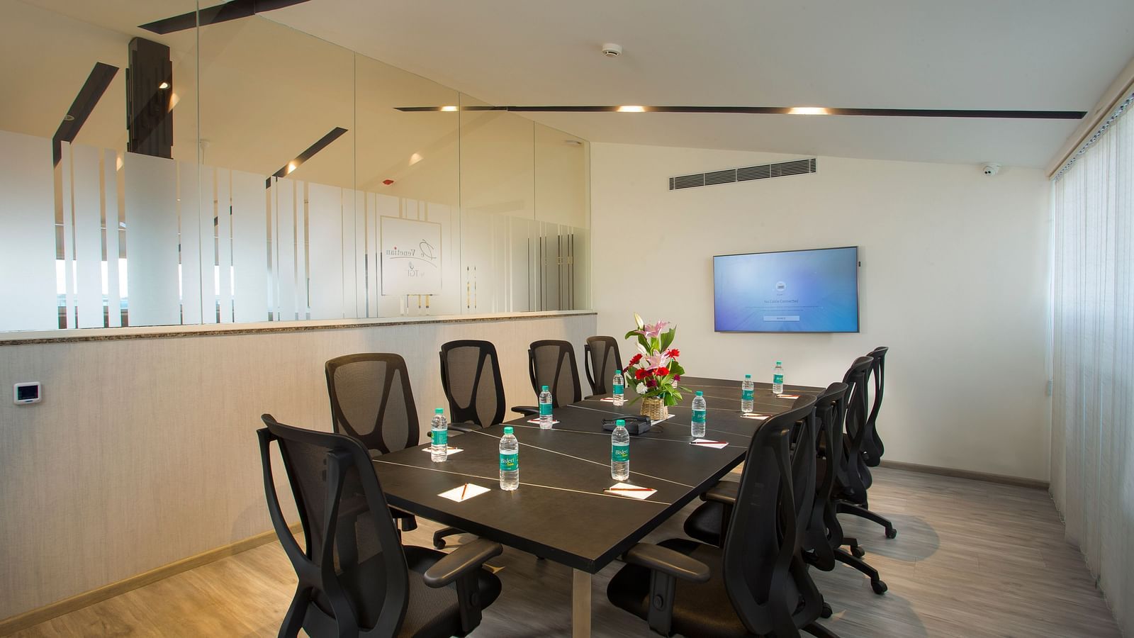 Another angle of the conference room showing a glass partition and a whiteboard - De Venetian by TGI, Brookefield
