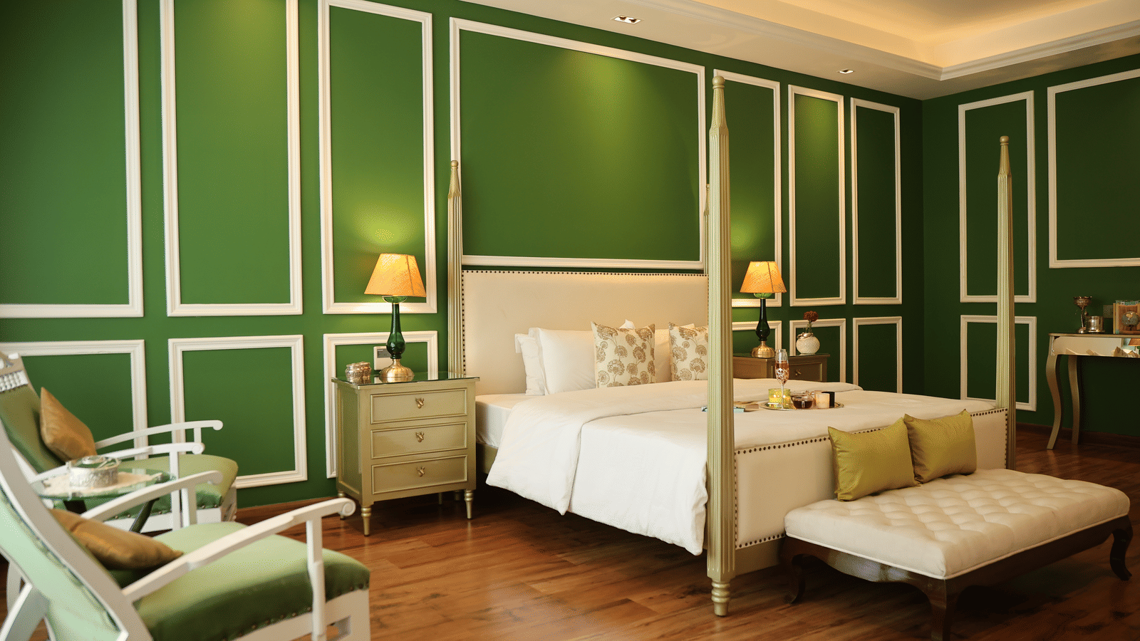 A room at Dileep Kothi, Jaipur with a double bed, side tables with night lamps and green walls