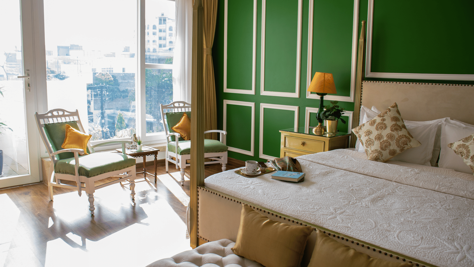 A room at Dileep Kothi, Jaipur with a double bed and a coffee table arrangement placed in front of a sliding door