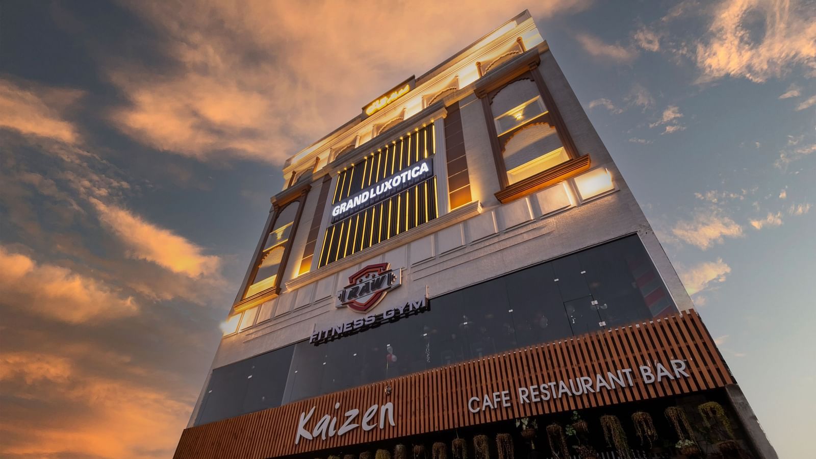 An angular shot of the facade of DLS Grand Luxotica, Dehradun under a vibrant twilight sky