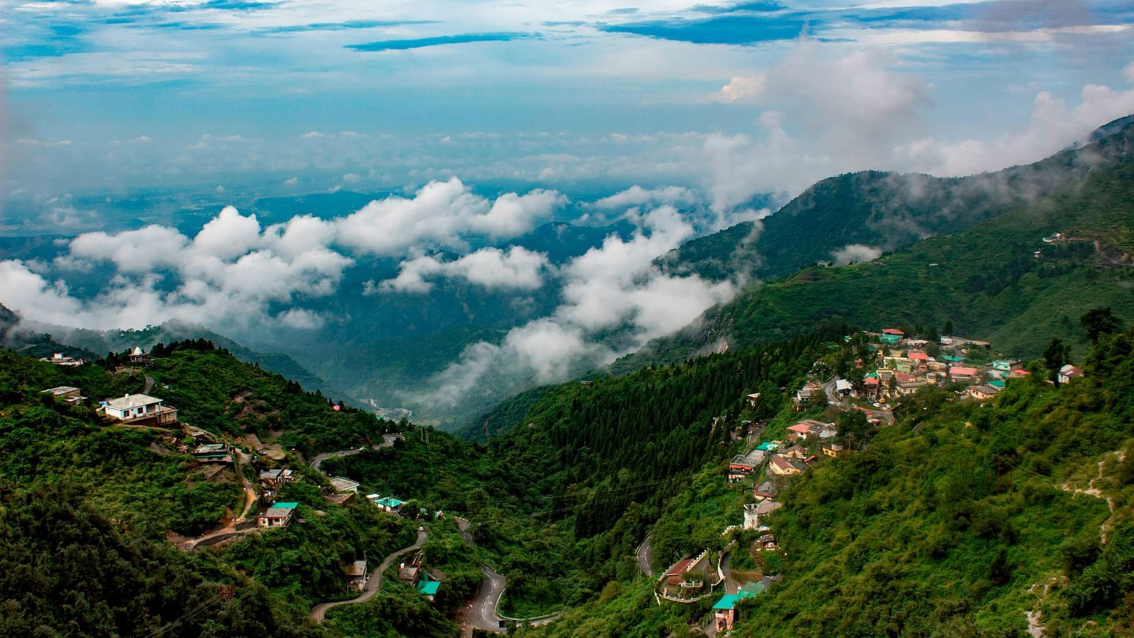 a serene landscape of mussoorie with clouds in the sky