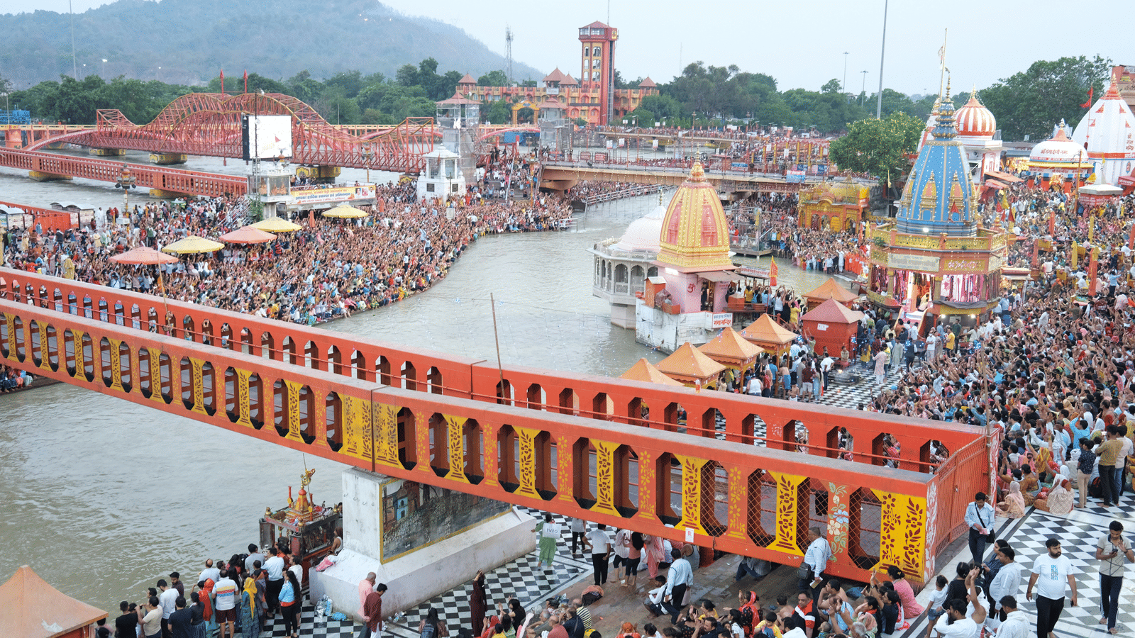 A view from the top of Har ki Pauri in Haridwar with people standing near the ghat section of the ganga river.