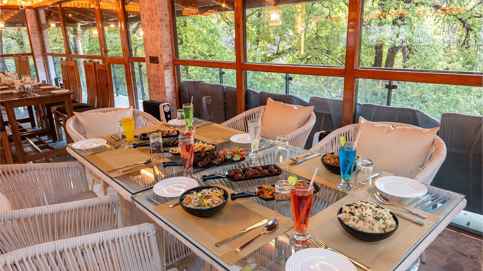 An image of the restaurant chairs and tables with food platters laid on it - DLS The Emerald, Nainital