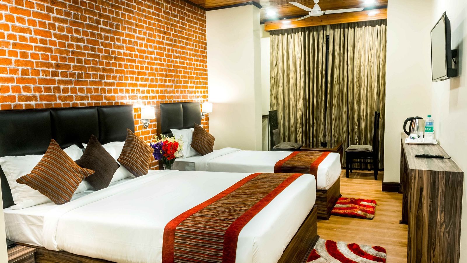 An image of a premium room with with twin beds, bed side tables, flat screen tv, chairs and tables, and other amenities - Ecotel Tin Tin, Bijanbari