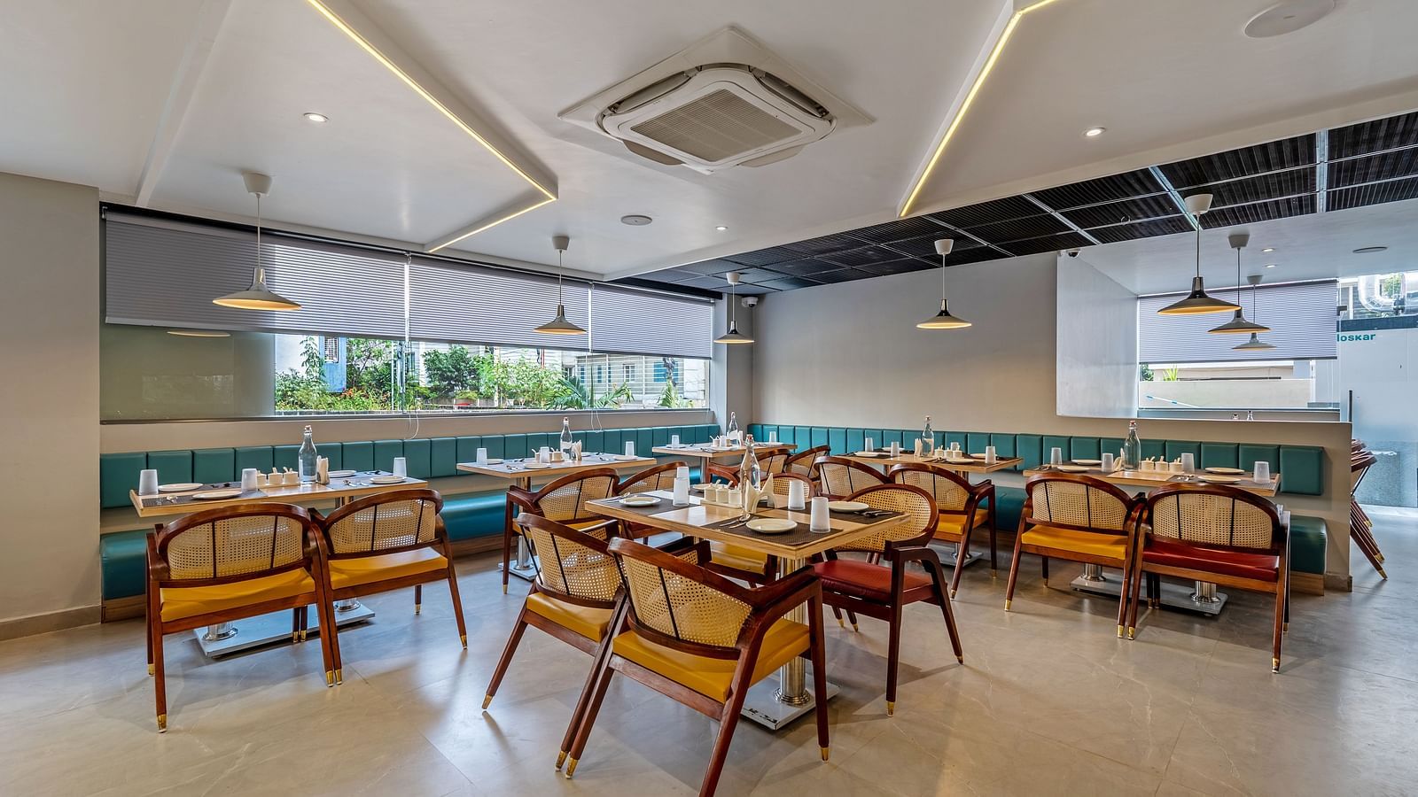 Shot of the in-house restaurant at the hotel featuring a fine dining setup featuring wooden tables and chairs | Eminent Suites & Apartments, Hi-Tech City 