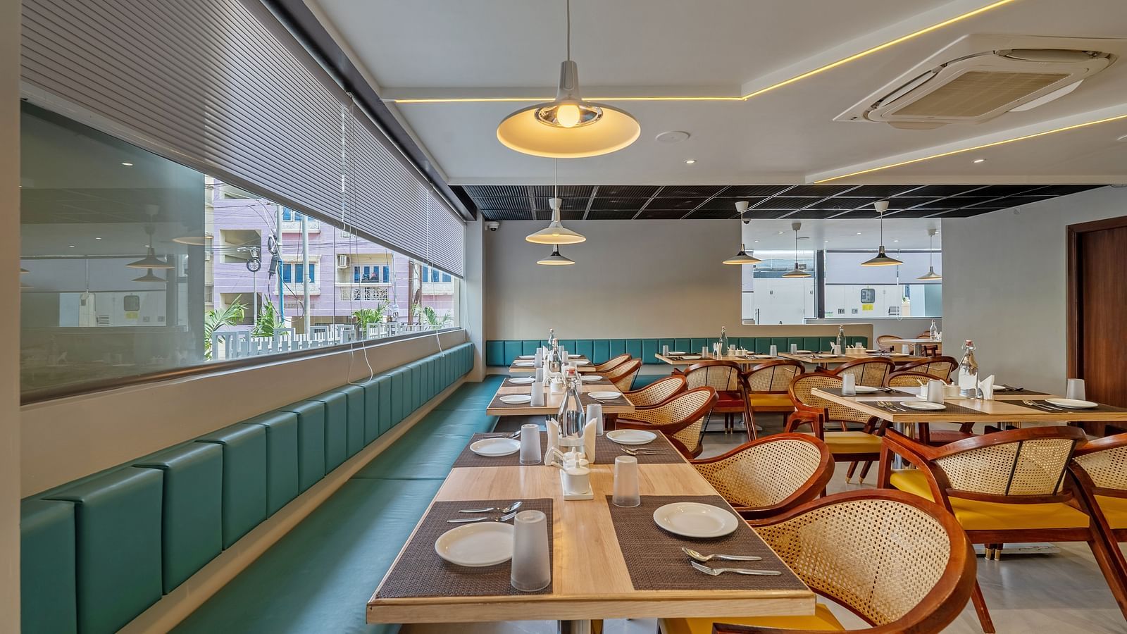 A close up shot of the in-house restaurant at the hotel featuring a fine dining setup featuring wooden tables and chairs | Eminent Suites & Apartments, Hi-Tech City 