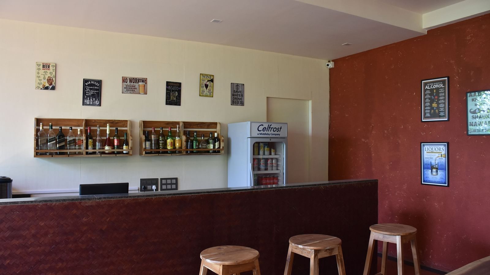 The bar area at Forest Escapes Koyna features stools and a counter, ready to serve guests.