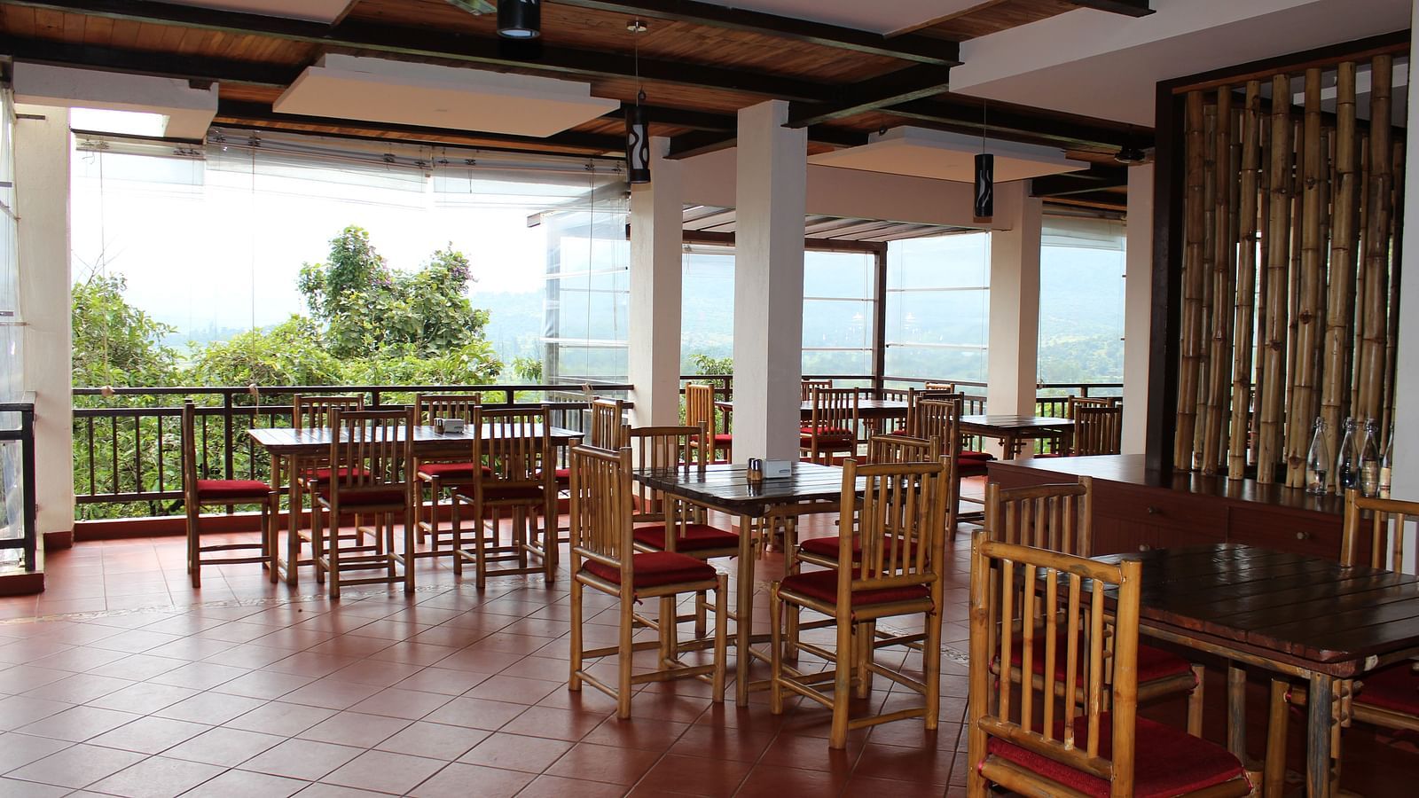 Guests can enjoy meals with a scenic view in the dining area at Forest Escapes Koyna.
