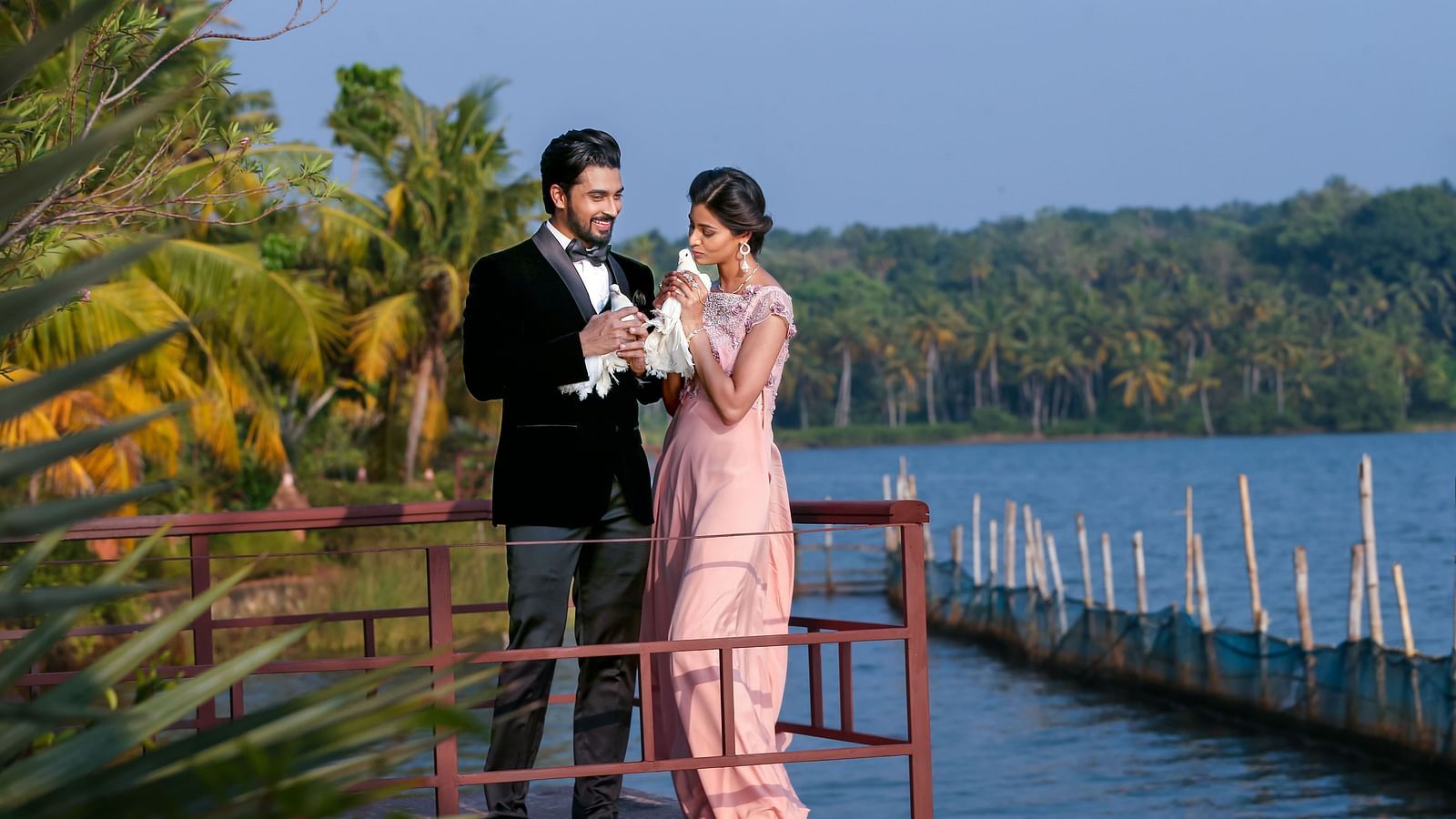 A couple’s wedding photoshoot by the lake, surrounded by trees.