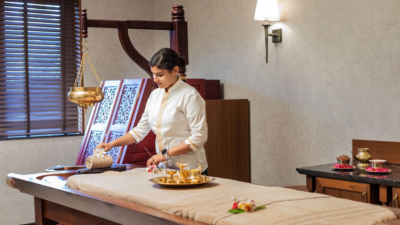 A spa room where a woman can be seen making arrangement for a session - Gamyam Retreat