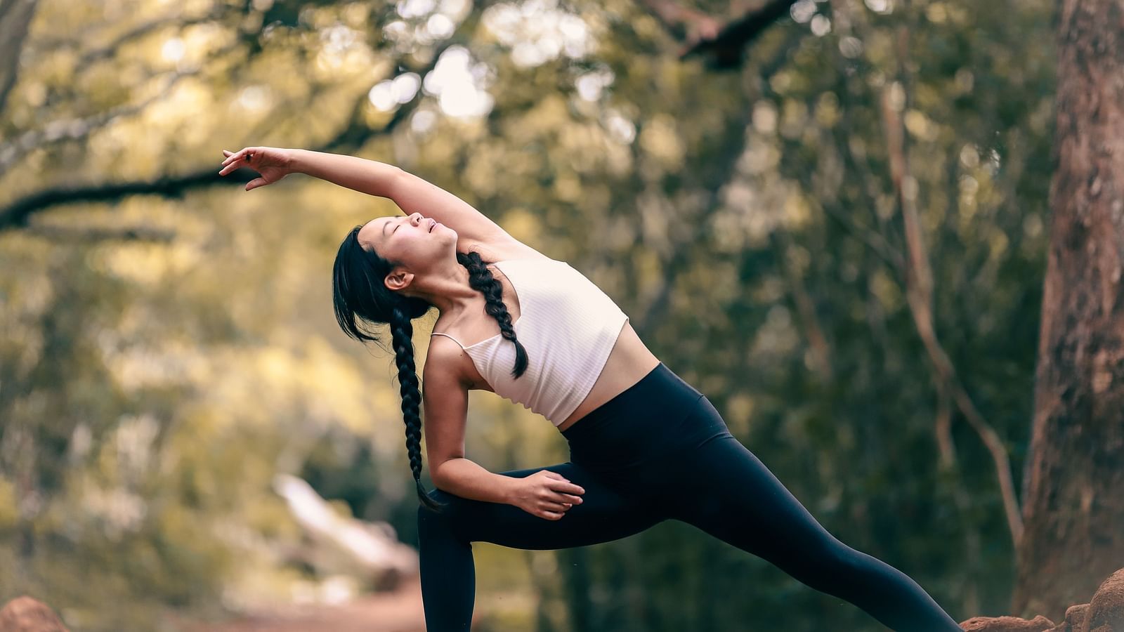 an image of a woman doing yoga stretches with a forest in the background