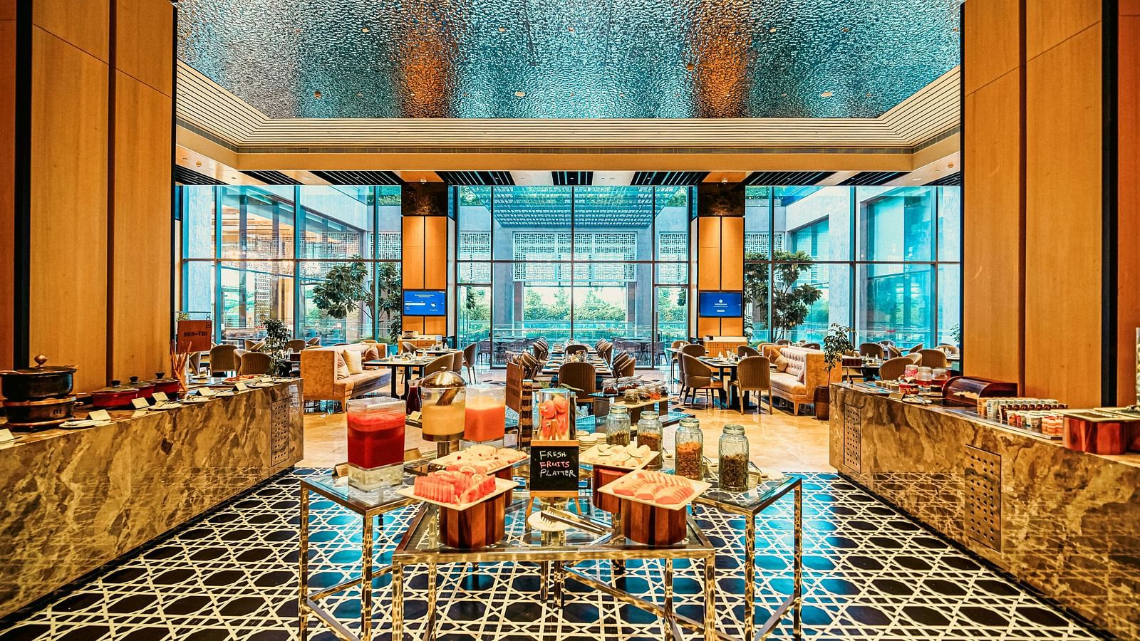 A vibrant buffet setup with fresh juices and fruit platters, framed by sleek and elegant decor - Grand Madurai by GRT Hotels