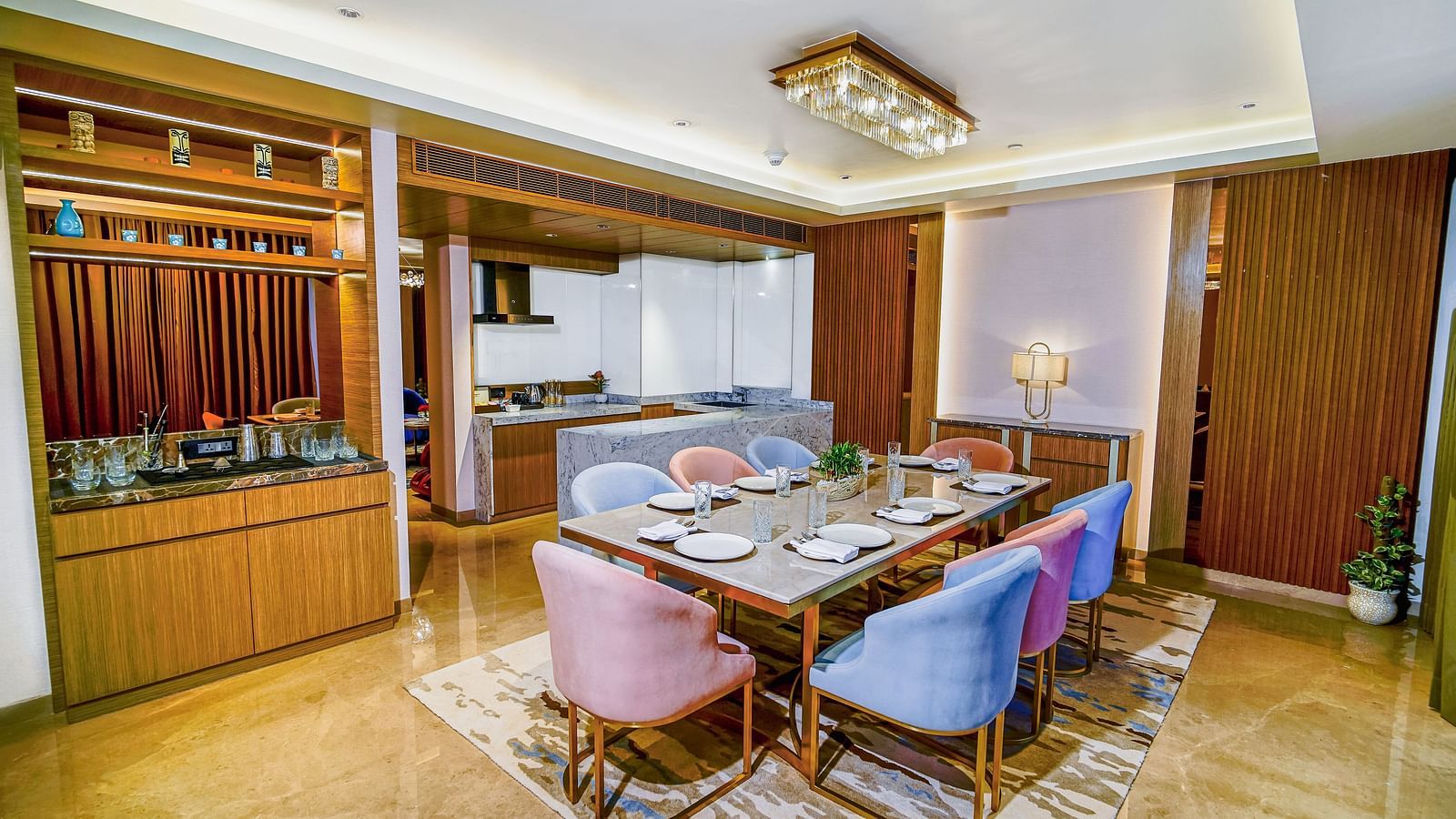 A dining room in Grand Velammal Suite with upholstered chairs placed around a square-shaped glass table - Grand Madurai by GRT Hotels