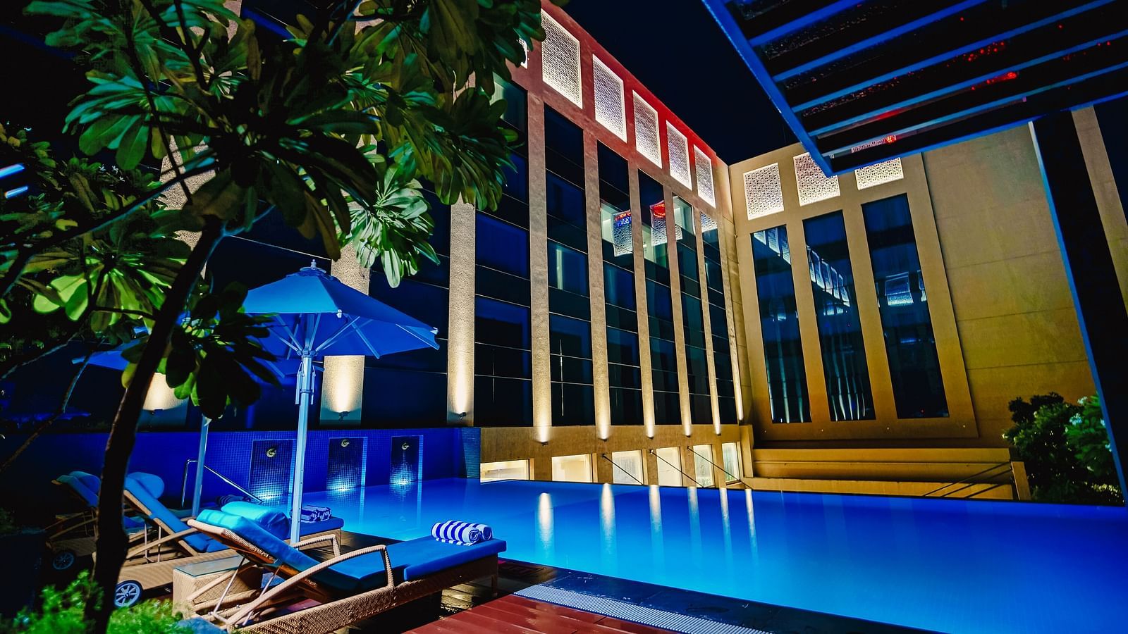 A luxurious pool area illuminated at night, offering a serene and relaxing atmosphere for guests - Grand Madurai by GRT Hotels