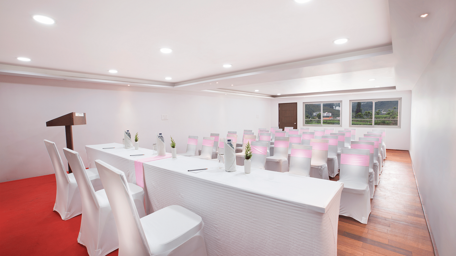An image of a banquet space which is brightly lit with seating arrangement - GReaT Trails Kodaikanal By GRT Hotels