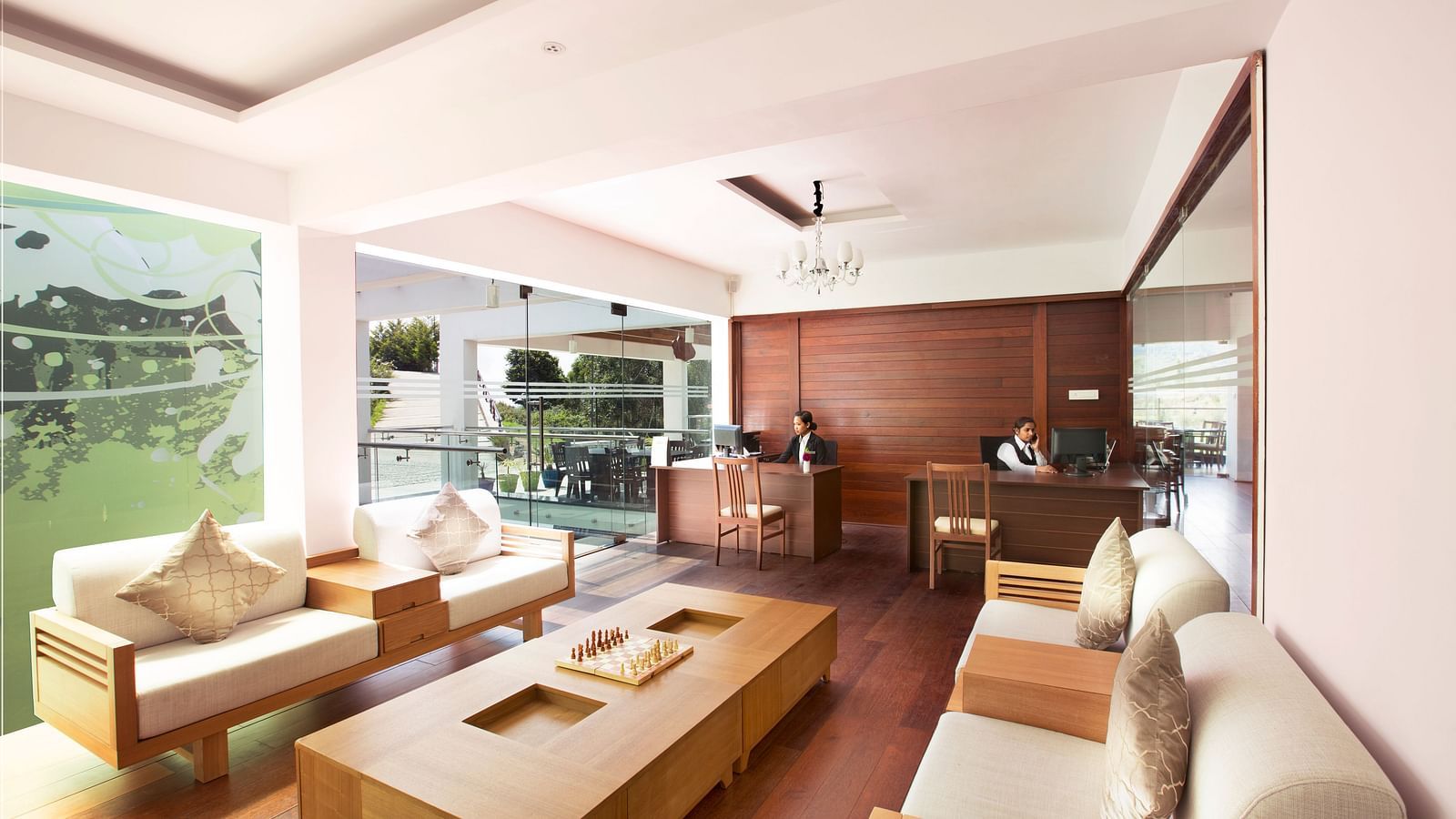 An image of the reception area with the reception desk and the waiting area with sofas and centre table - GReaT Trails Kodaikanal By GRT Hotels