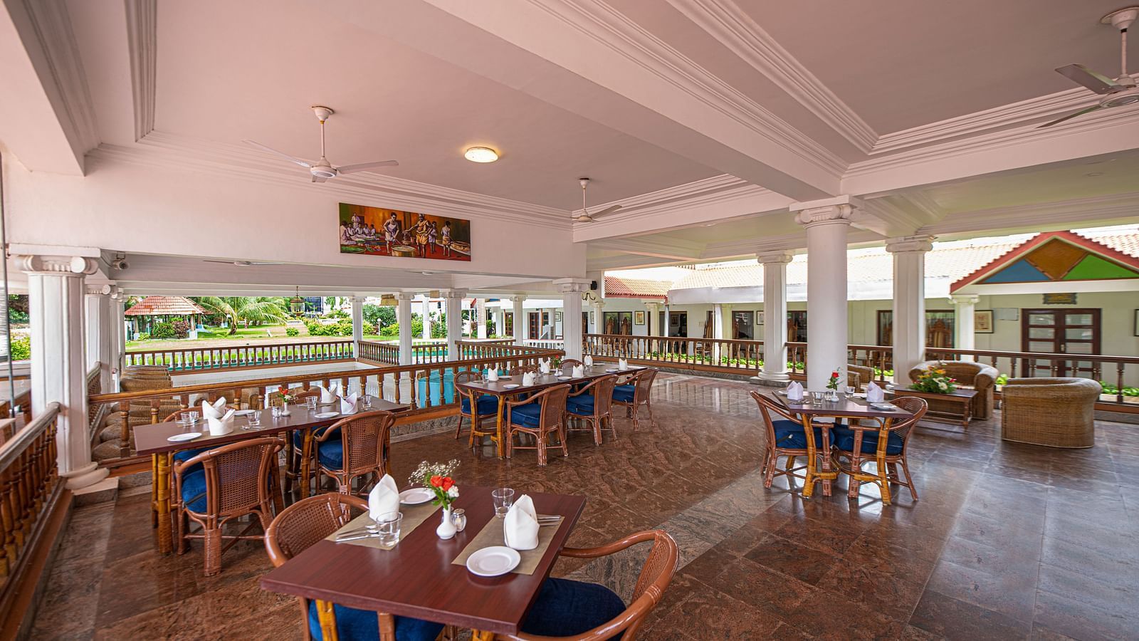 An image of the outdoor dining area featuring tables and chair at GReaT Trails River View Resort Thanjavur By GRT Hotels