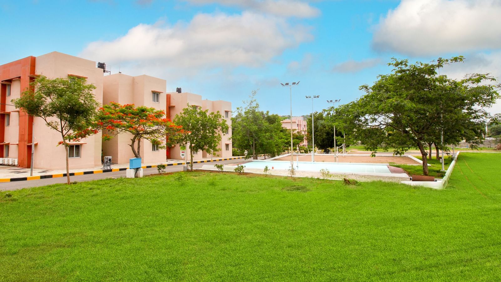 Panoramic view of Greens Inn with a lawn in front of it - Spacious Hotel Grounds in Hyderabad.