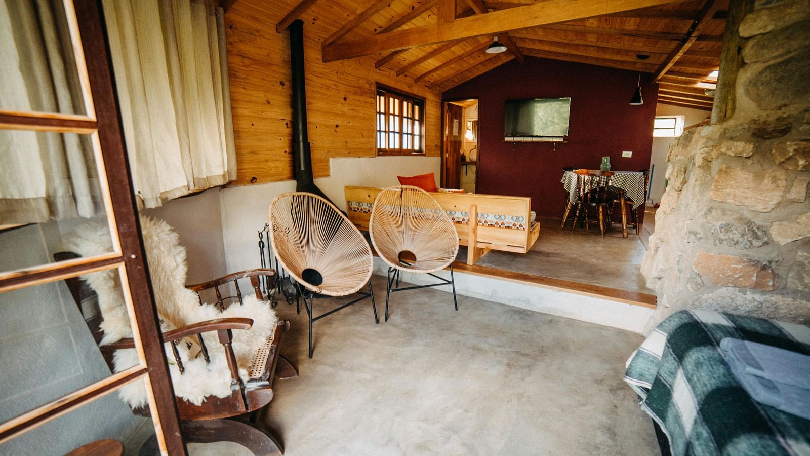 Rustic wooden cabin interior with a chair, table, and vintage decor, creating a cosy atmosphere.