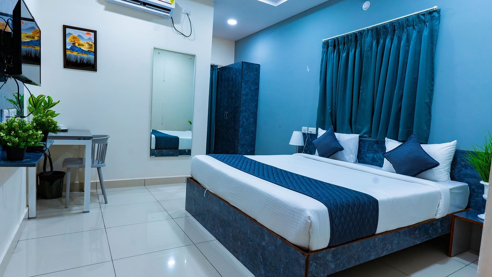 An image of a bedroom with king size bed, bedside table next to it, AC, flat TV screen, etc. - Hotel Aerotel, Hyderabad - A Unit of Comfort Hometel