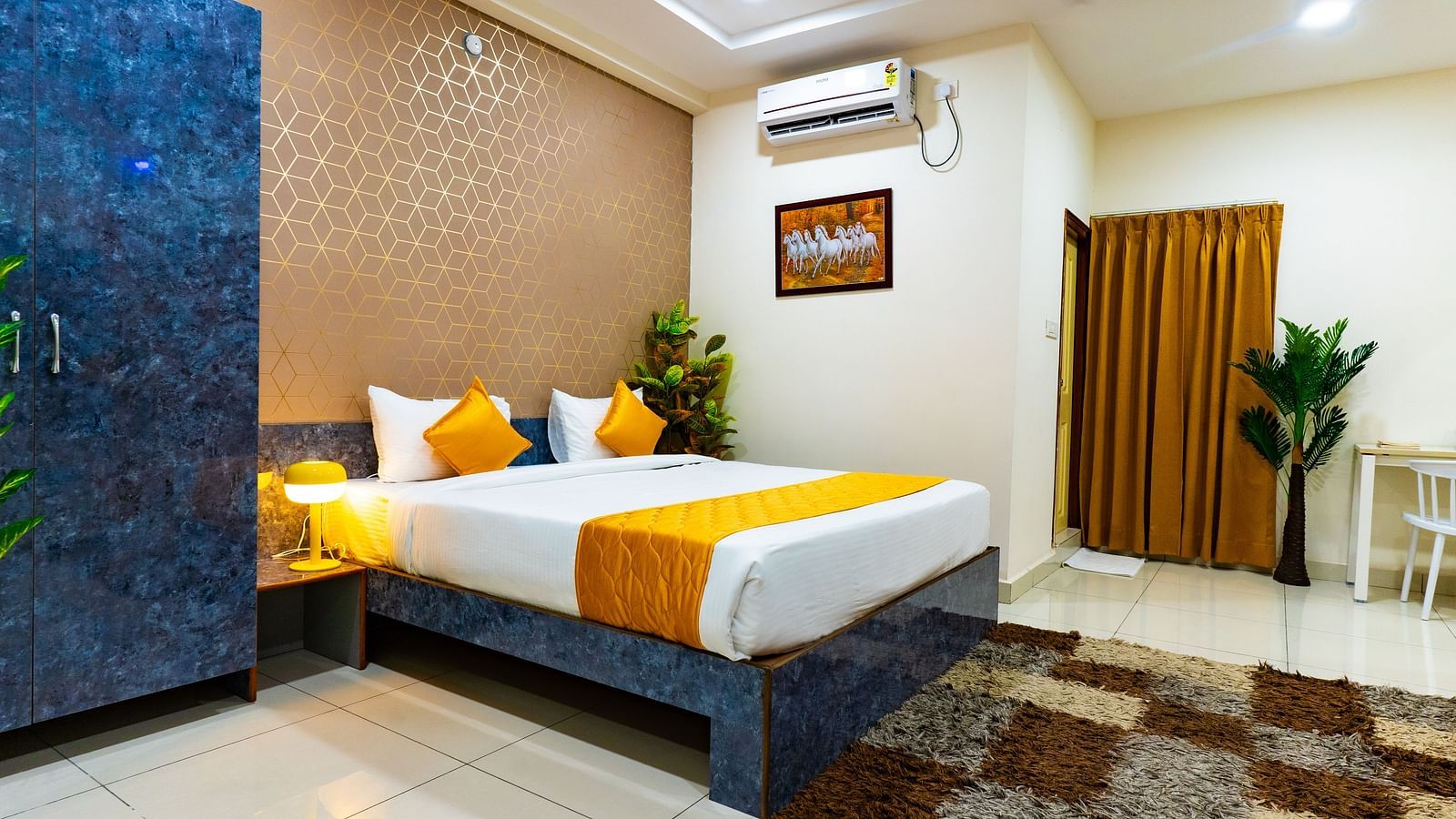 An image of a bedroom equipped with AC, wardrobe, and a table - Hotel Aerotel, Hyderabad - A Unit of Comfort Hometel