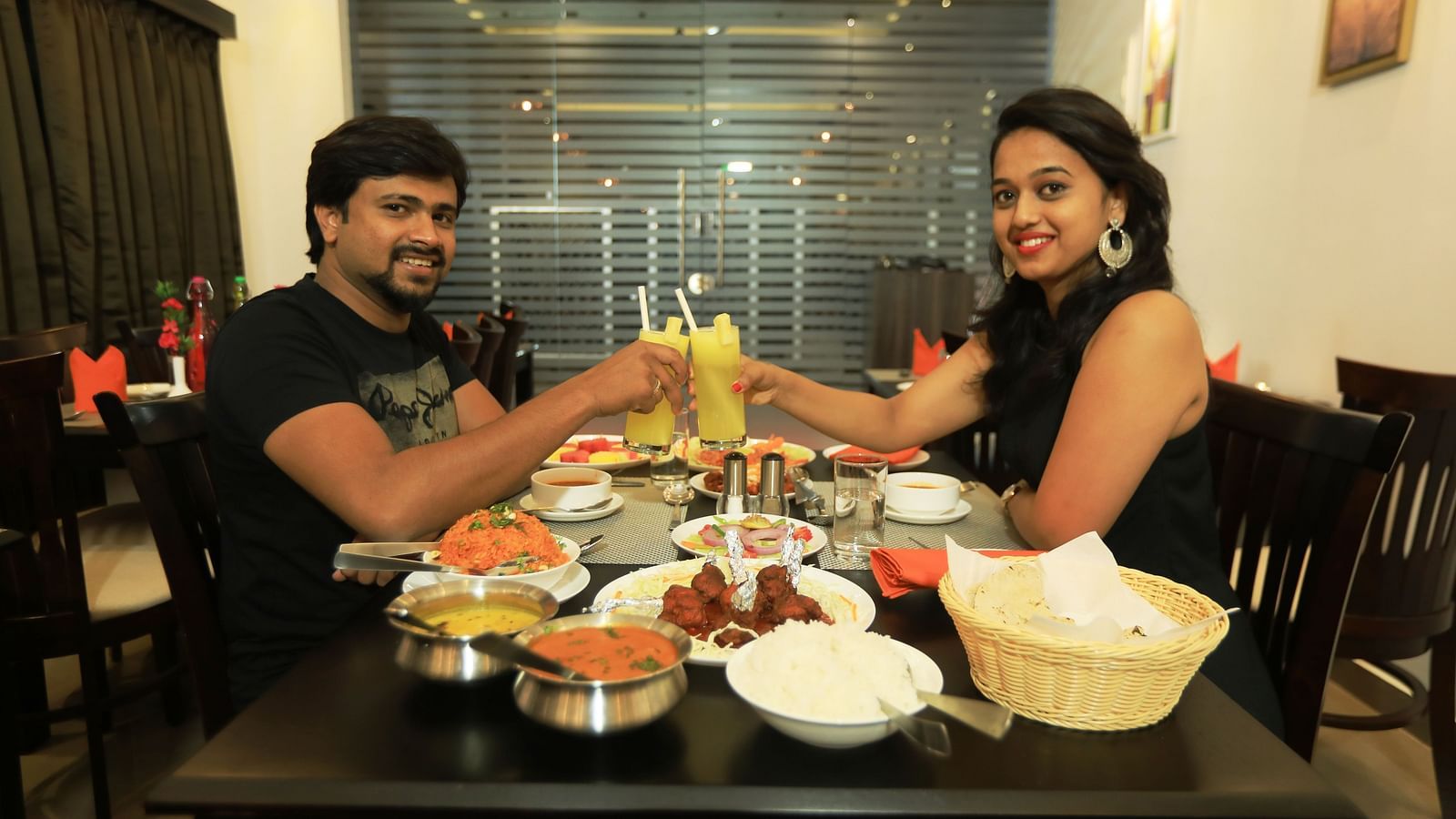 Image of a man and a woman holding up glasses of drinks at Hotel Altitude, Madikeri.