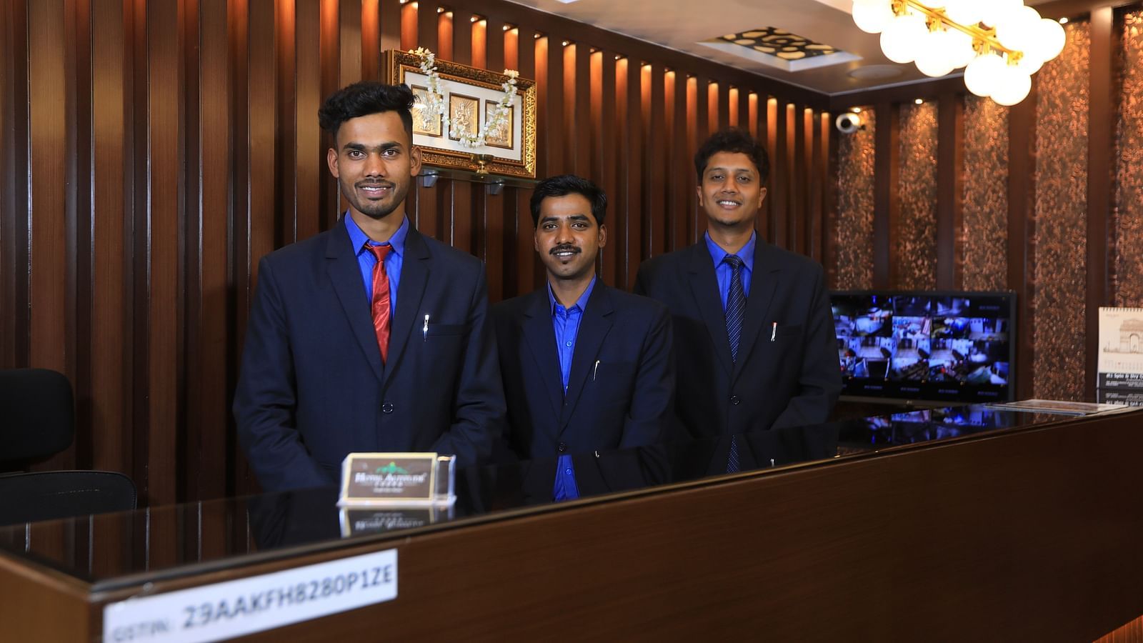 Image of three people standing behind a table and posing for the lens at Hotel Altitude, Madikeri.