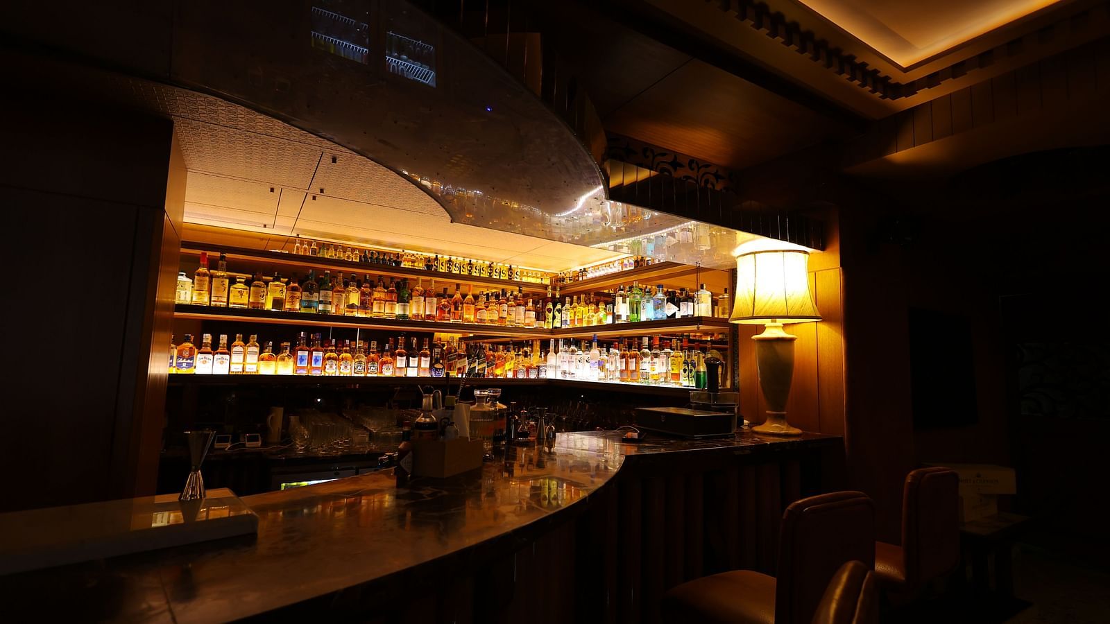Image of the bar area of JBs lounge at Hotel Amar with a filly stocked bar rack