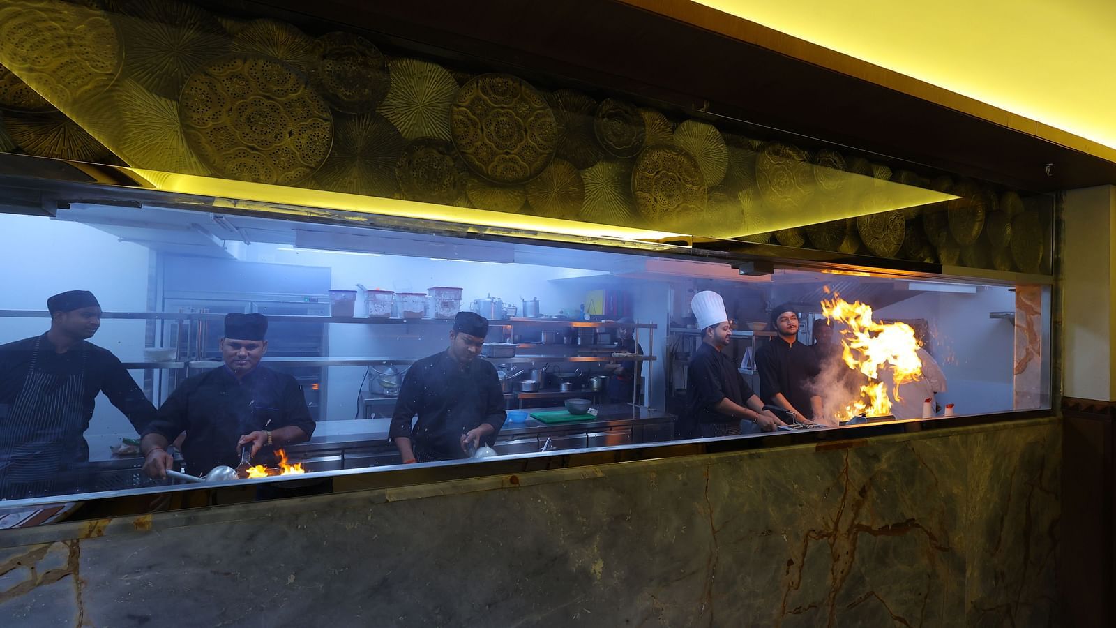 Image of chefs cooking with high flame the anam restaurant of Hotel Amar