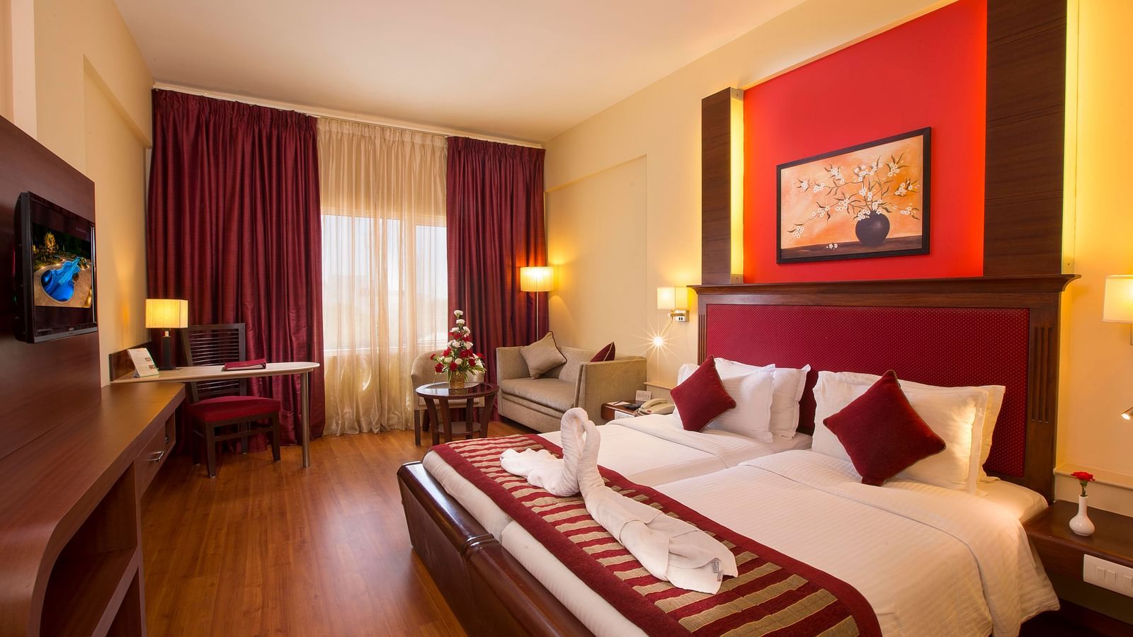 Superior Room featuring twin beds, sofa and a television at Hotel Atithi - TGI Grand, Pondicherry