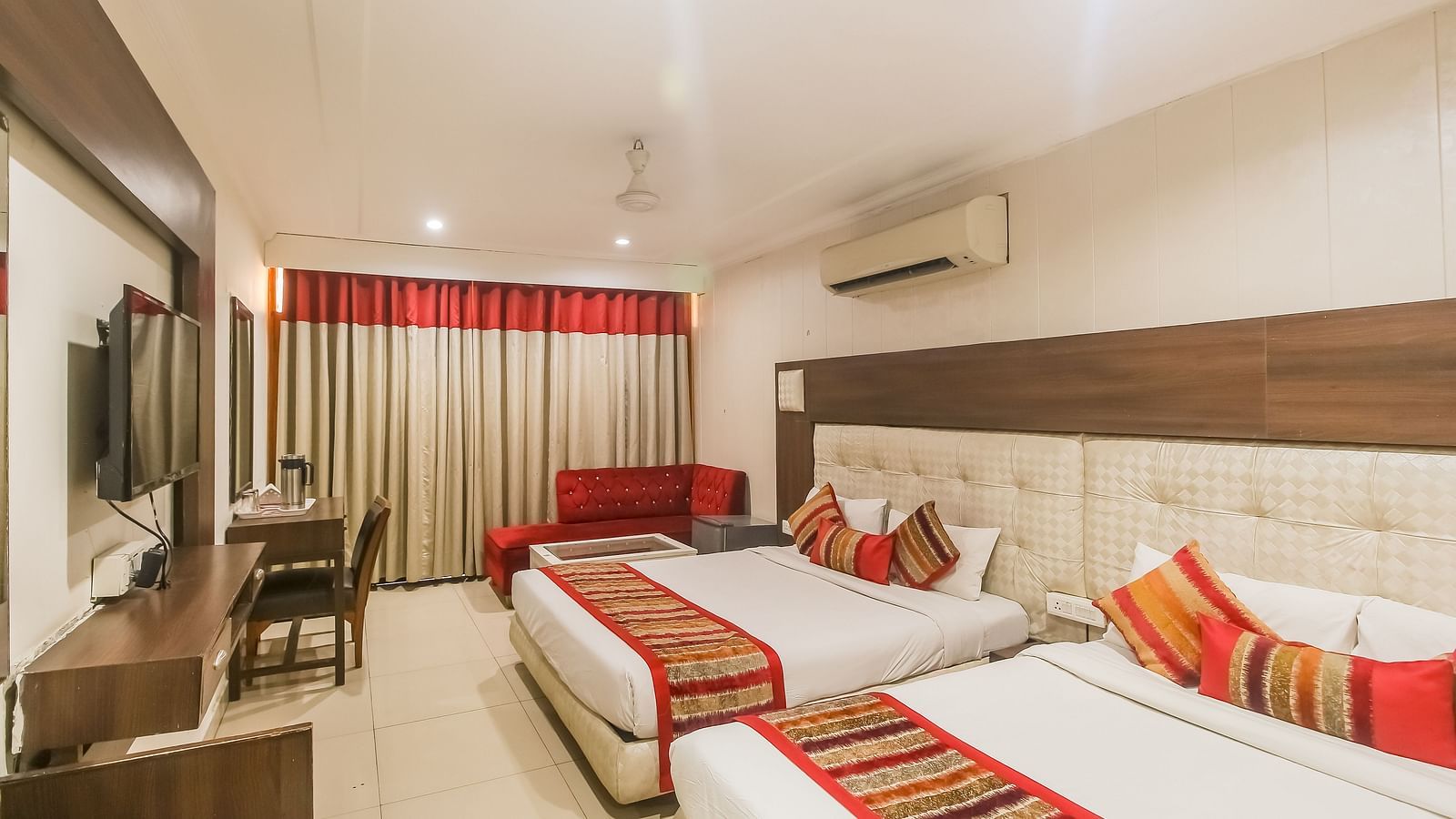 Family Room featuring a work desk, large window with curtains, and two queen sizebeds -  Hotel Diamond Plaza, Chandigarh.