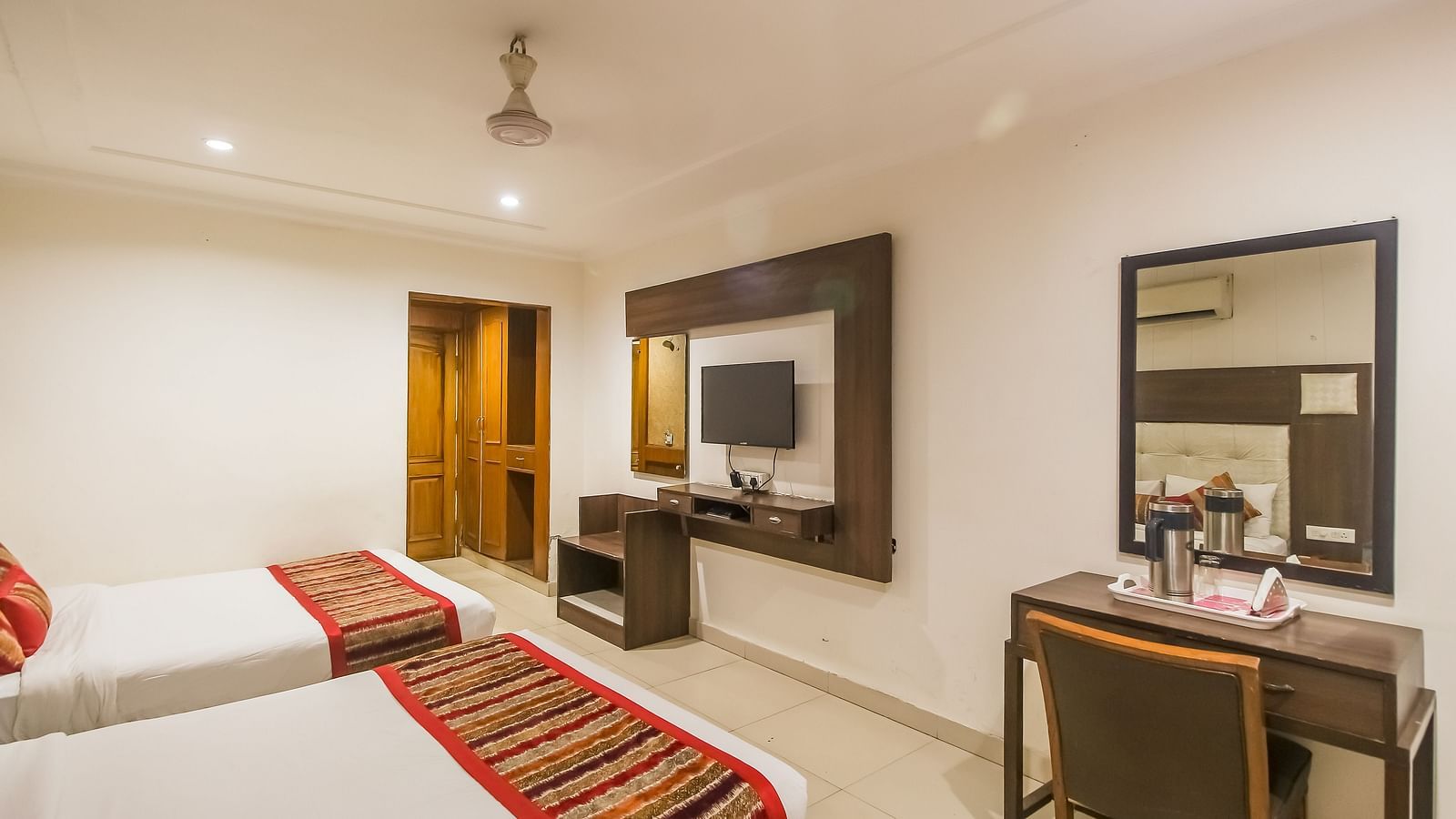 Well-lit Family Room with two queen size beds, wooden accents, and contemporary furnishings - Hotel Diamond Plaza, Chandigarh.