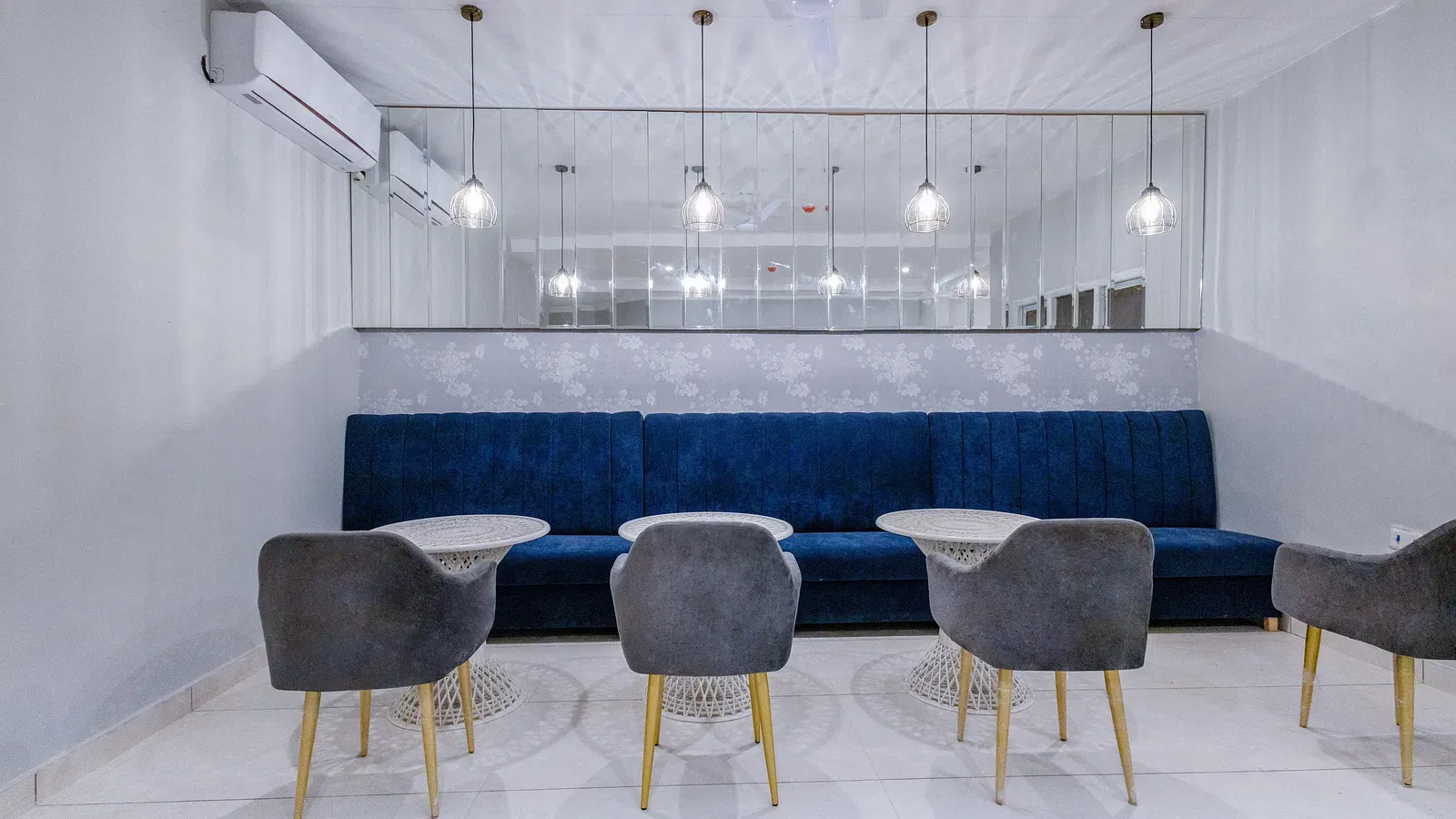Restaurant area featuring modern chairs and tables against a dark blue wall. - Hotel Downtown17, Chandigarh 