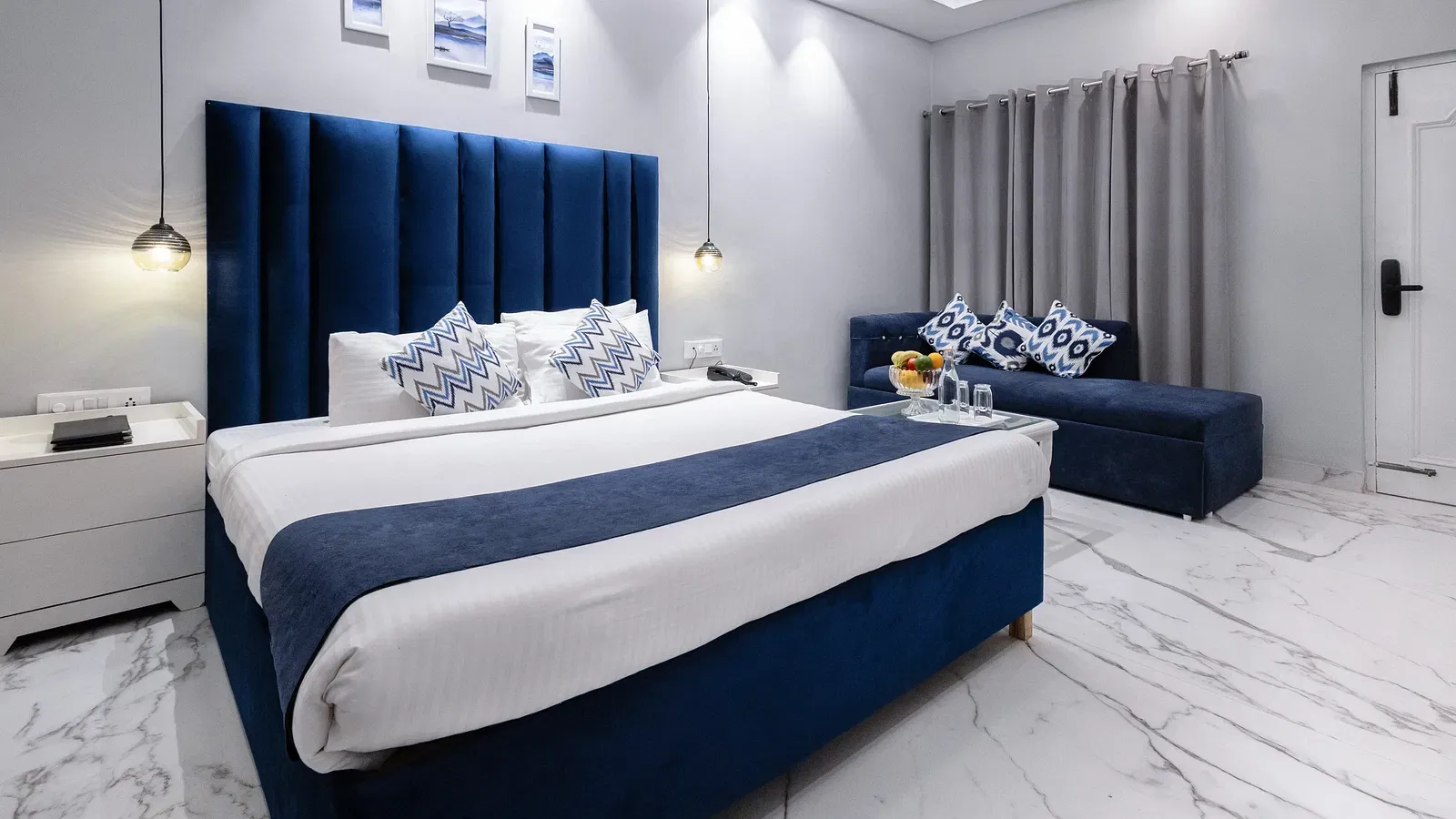 Super Deluxe Room featuring a king size bed with a blue accent, a seating area, and a marble floor. - Hotel Downtown17, Chandigarh