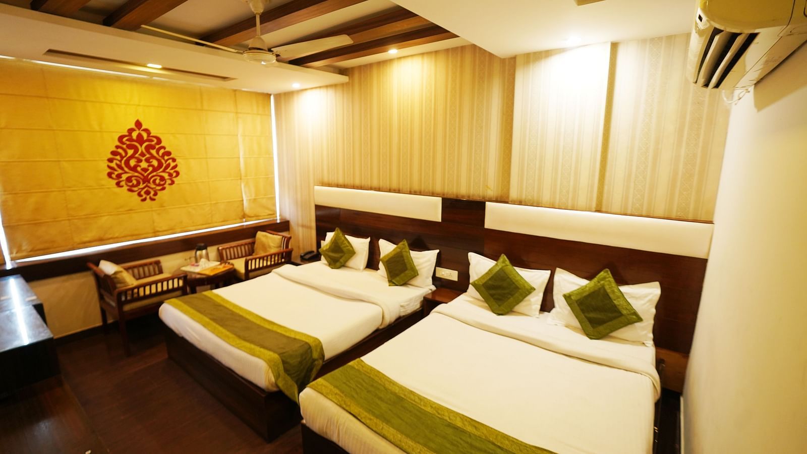 Family Room featuring two beds, a decorative wall design, and an air-conditioning unit.- Hotel Dreamland, Chandigarh
