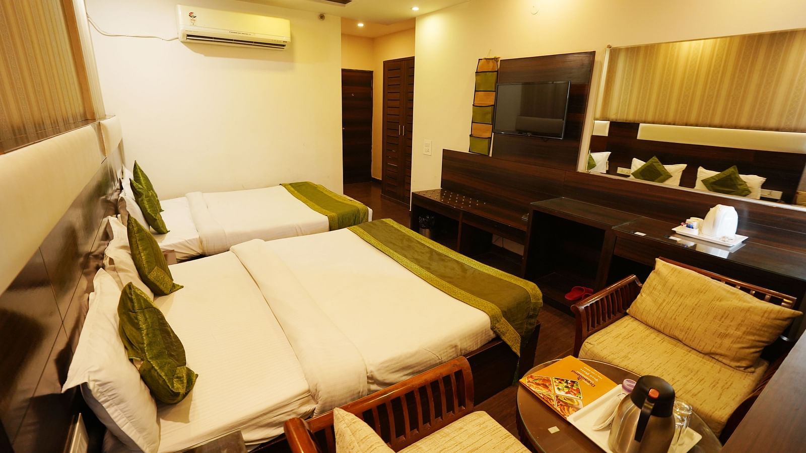 Family Room featuring two beds, a seating area, and a desk.- Hotel Dreamland, Chandigarh